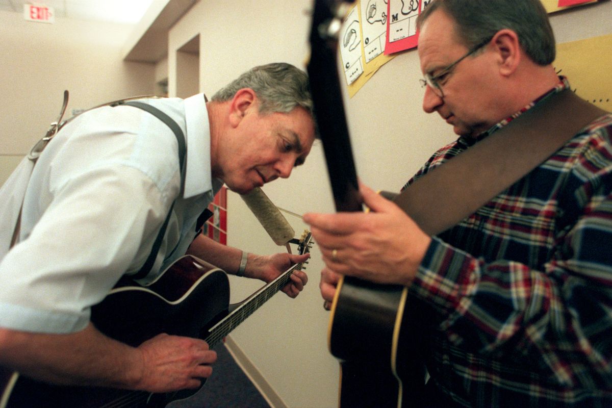 Frank Wagner, left, moves in to hear the tone of Rod Anderson’s guitar in 1999. (File)