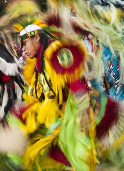 Colville Tribe member Lawrence McDonald is a blur of motion as he dances in his regalia during the Grand Entry of the 2012 Spokane Falls Northwest Indian Encampment and Powwow in Riverfront Park on Friday night. (Colin Mulvany)