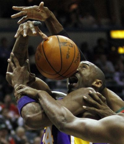 Los Angeles Lakers’ Kobe Bryant is fouled as he drives to the basket in the first half of an overtime win over Milwaukee.  (Associated Press)