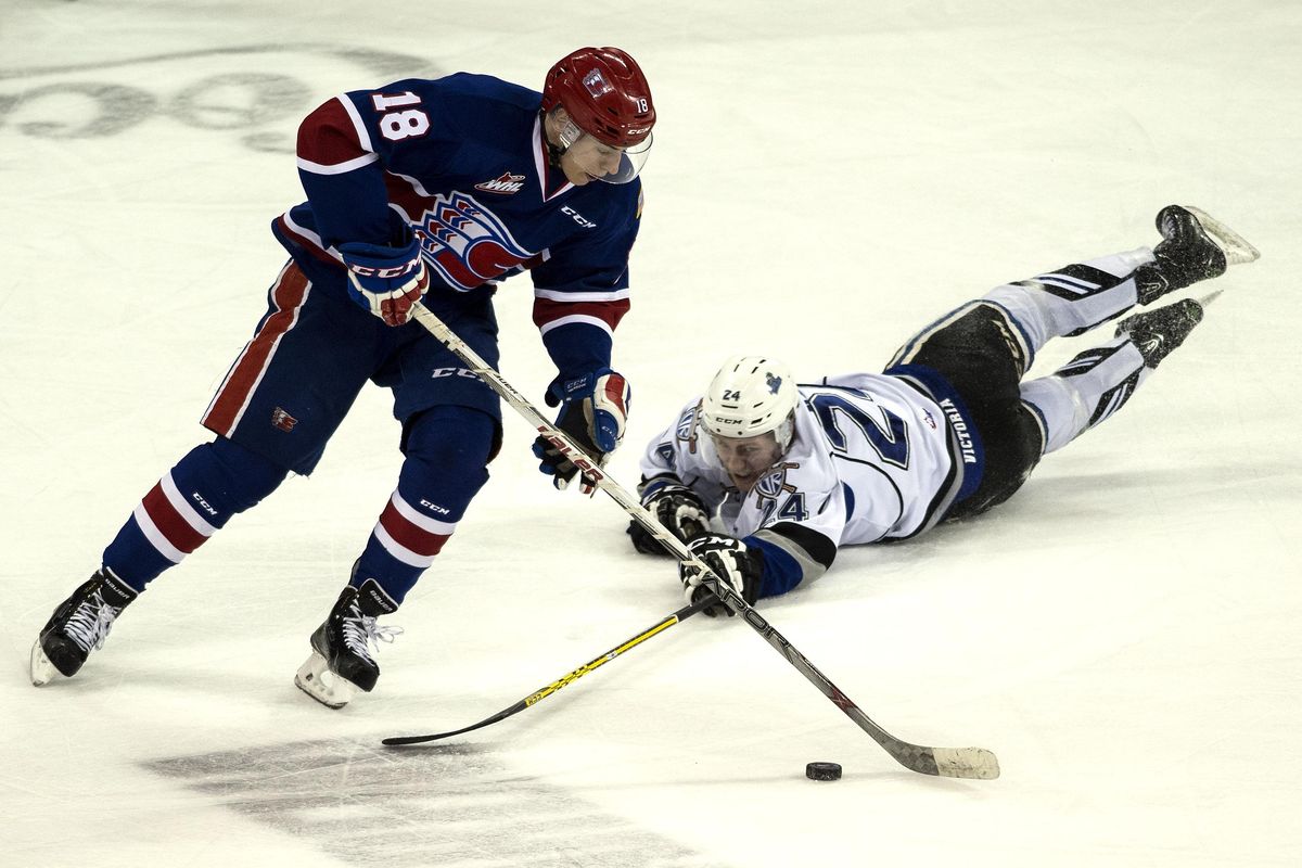 After Victoria Royals right wing Regan Nagy (24) falls, Spokane Chiefs center Curtis Miske (18) gains control of the puck during the first period of a WHL hockey game, Tues., March 29, 2016, at the Spokane Arena in Spokane, WA. (Colin Mulvany / The Spokesman-Review)