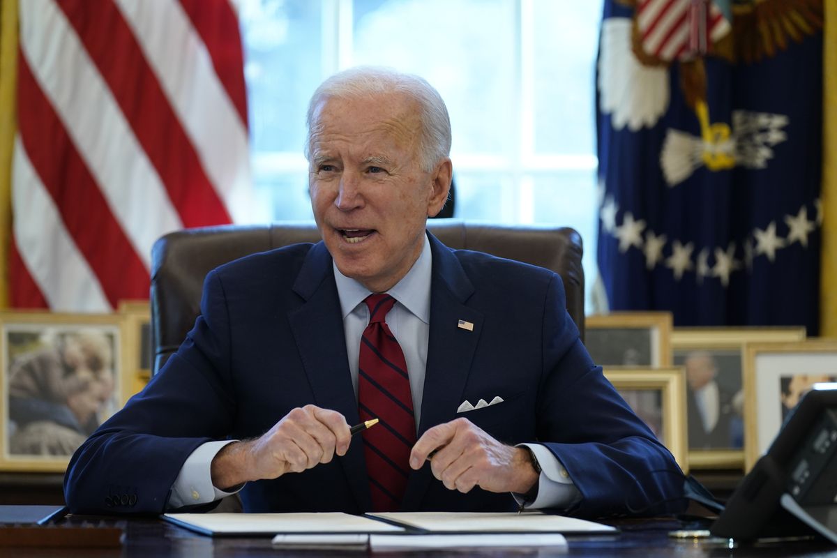 President Joe Biden signs a series of executive orders on health care, in the Oval Office of the White House, Thursday, Jan. 28, 2021, in Washington. The Democratic push to raise the minimum wage to $15 an hour has emerged as an early flash point in the push for a $1.9 trillion COVID relief package, providing an early test of President Joe Biden