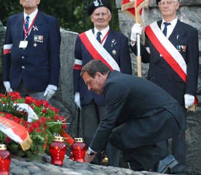 
German Chancellor Gerhard Schroeder places a candle at the Warsaw Uprising Cemetery in Warsaw, Poland, on Sunday. 
 (Associated Press / The Spokesman-Review)