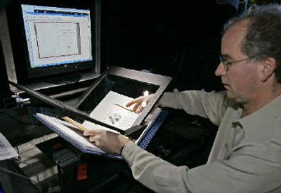 
Internet Archive founder Brewster Kahle prepares a book for digital scanning Monday in San Francisco. 
 (Associated Press / The Spokesman-Review)