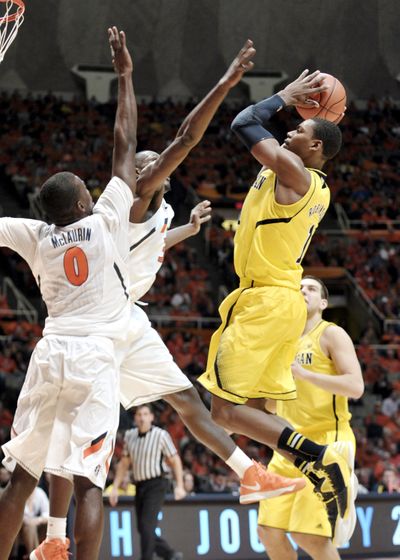 Michigan’s Glenn Robinson III, right, pulls up in front of Illinois’ Sam McLaurin (0) and Nnanna Egwu (32) on the way to 14 points. (Associated Press)