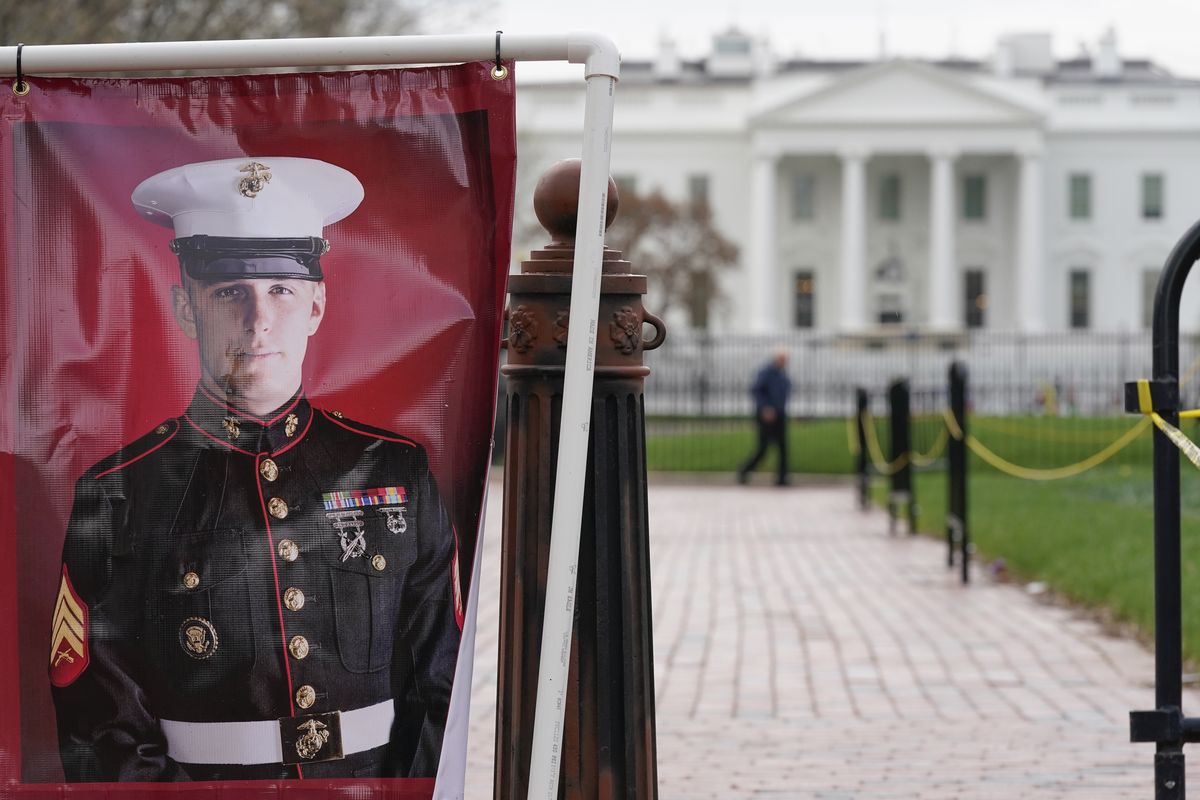 FILE - A poster photo of U.S. Marine Corps veteran and Russian prisoner Trevor Reed stands in Lafayette Park near the White House, March 30, 2022, in Washington.  (Patrick Semansky)