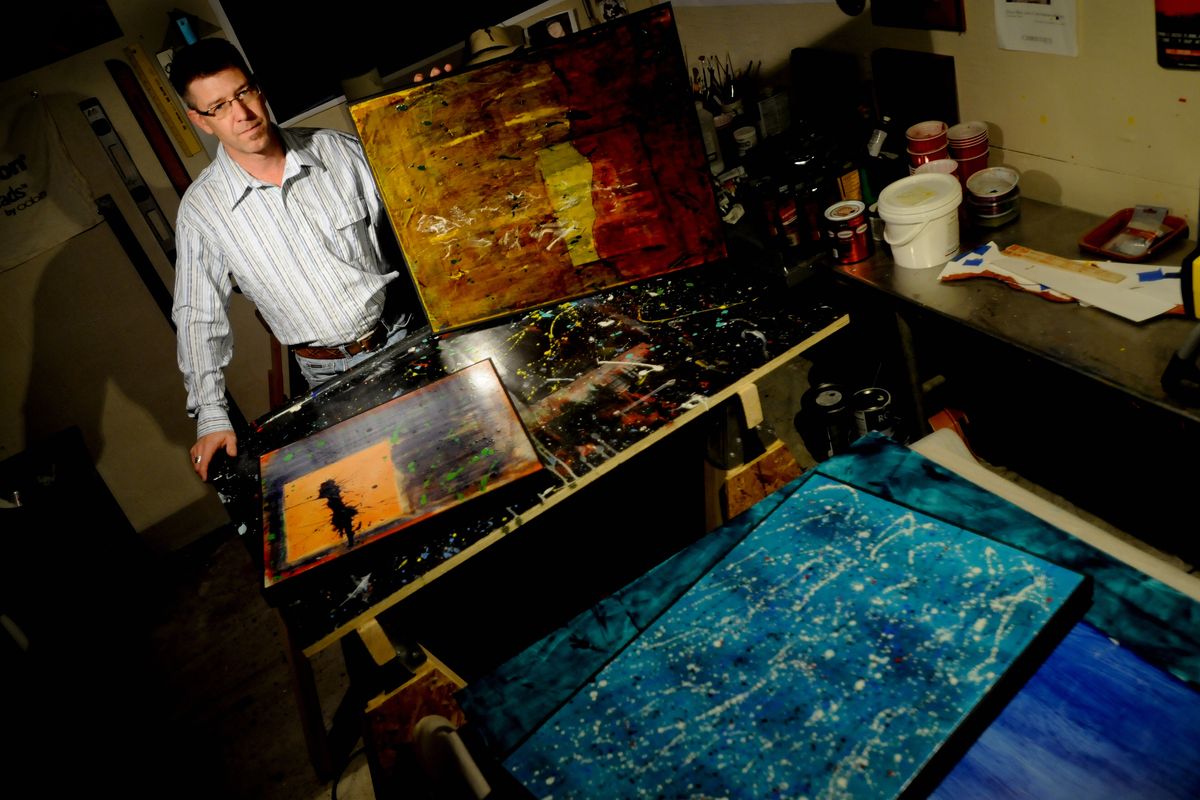 Artist Jeffrey Loyd poses for a photo with some of his recent works on Oct. 17 at his studio in downtown Spokane. (Tyler Tjomsland)