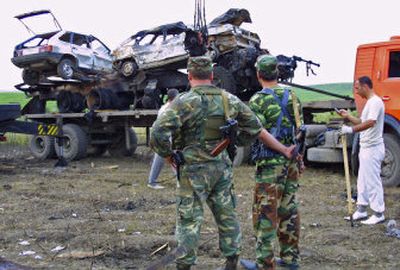 
Police officers look at a truck and two cars destroyed at the site where Chechen warlord Shamil Basayev and other rebels were killed in a special operation  on Monday. 
 (Associated Press / The Spokesman-Review)