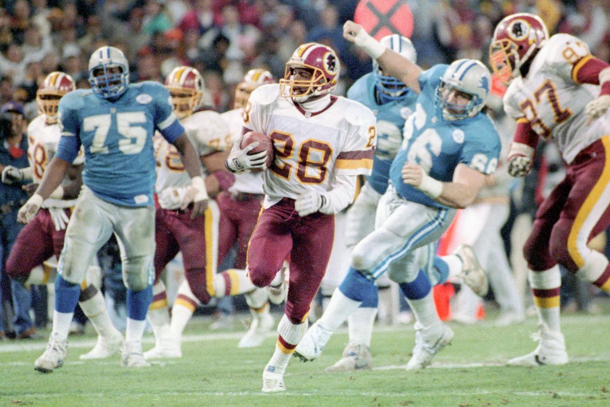 Darrell Green, center, runs an interception back for a touchdown during Washington’s trouncing of the Detroit Lions in the NFC championship game at RFK Stadium in 1992.  (Rich Lipski/The Washington Post)