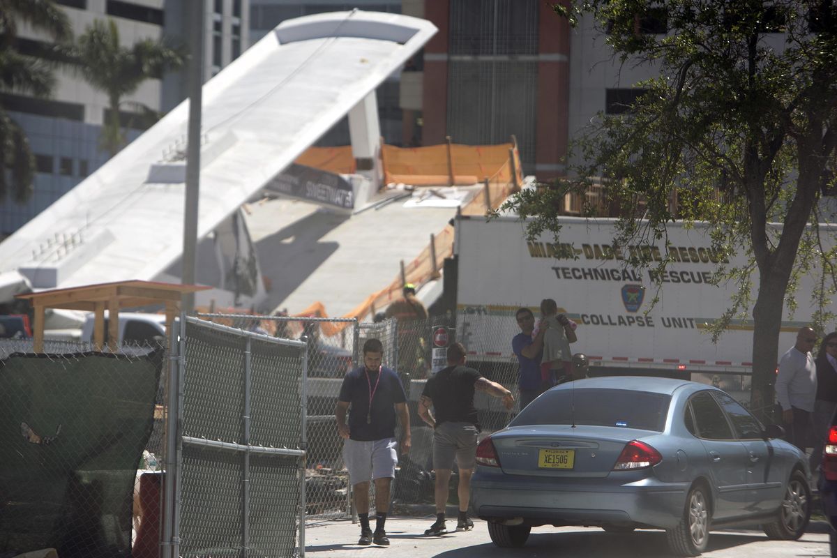 People move away from the area where a pedestrian bridge connecting the Florida International collapsed, Thursday, March 15, 2018 in the Miami area. The brand-new pedestrian bridge collapsed onto a highway crushing at least five vehicles. Several people were seen being loaded into ambulances and authorities said they were searching for people. (Daniel A. Varela / Associated Press)