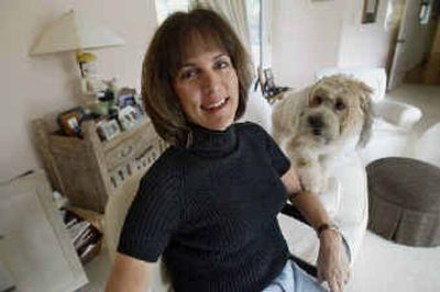 
TV writer Janis Hirsch poses at her home with her dog, Sophie, in Los Angeles. When Hirsch heard of a sexual harassment lawsuit filed by a former writer's assistant on 