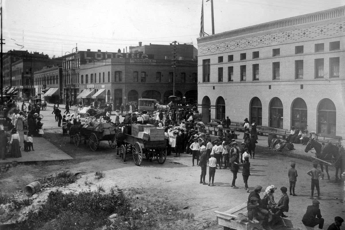 1905: Men and cargo wagons are loaded before heading southbound on Stevens Street in Spokane. The Tennessee House is the two-story building at the center of the photo.