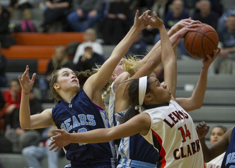 Central Valley's Courtney Carolan, left, and Madison Hovren (behind, center) and Lewis and Clark's Janieva Bates  (14) compete for a rebound during the first half of a GSL high school girl's basketball game, Tuesday, Feb. 4, 2014, at Lewis and Clark High School. (Colin Mulvany / The Spokesman-Review)
