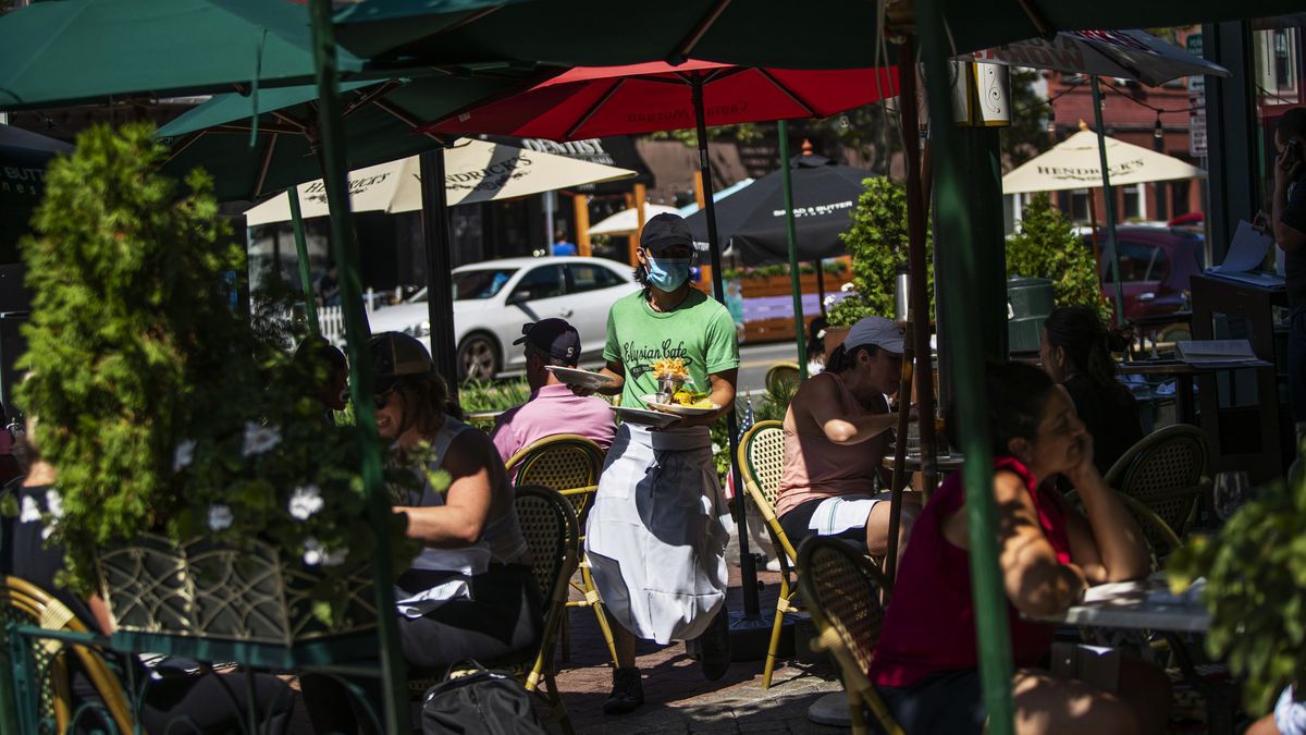 A waiter in a face mask delivers food to the tables outside of a local restaurant during lunch on Friday, Sept. 4, 2020, in Hoboken, N.J.  (Eduardo Munoz Alvarez)