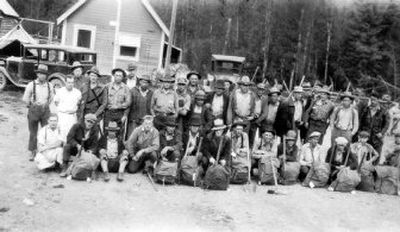 
Large group of men in front of buildings at Bismark Ranger Station. Some of the men have smokechaser packs. 
 (The Spokesman-Review)