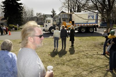 Monte Anderson and others of the Emerson and Garfield neighborhood gather Wednesday at the unveiling of a new garbage truck that can handle alley pickup by using mechanical arms on both sides.  (Christopher Anderson / The Spokesman-Review)