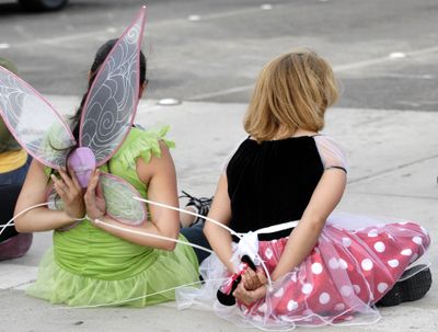 Protesters dressed as Tinker Bell and Minnie Mouse wait to be taken away after being arrested by police officers during a demonstration against Disney’s treatment of hotel workers. (Associated Press / The Spokesman-Review)