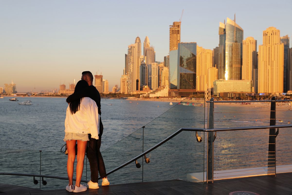 Tourists look at the skyline at sunset, in Dubai, United Arab Emirates, Tuesday, Jan. 12, 2021. Since becoming one of the world