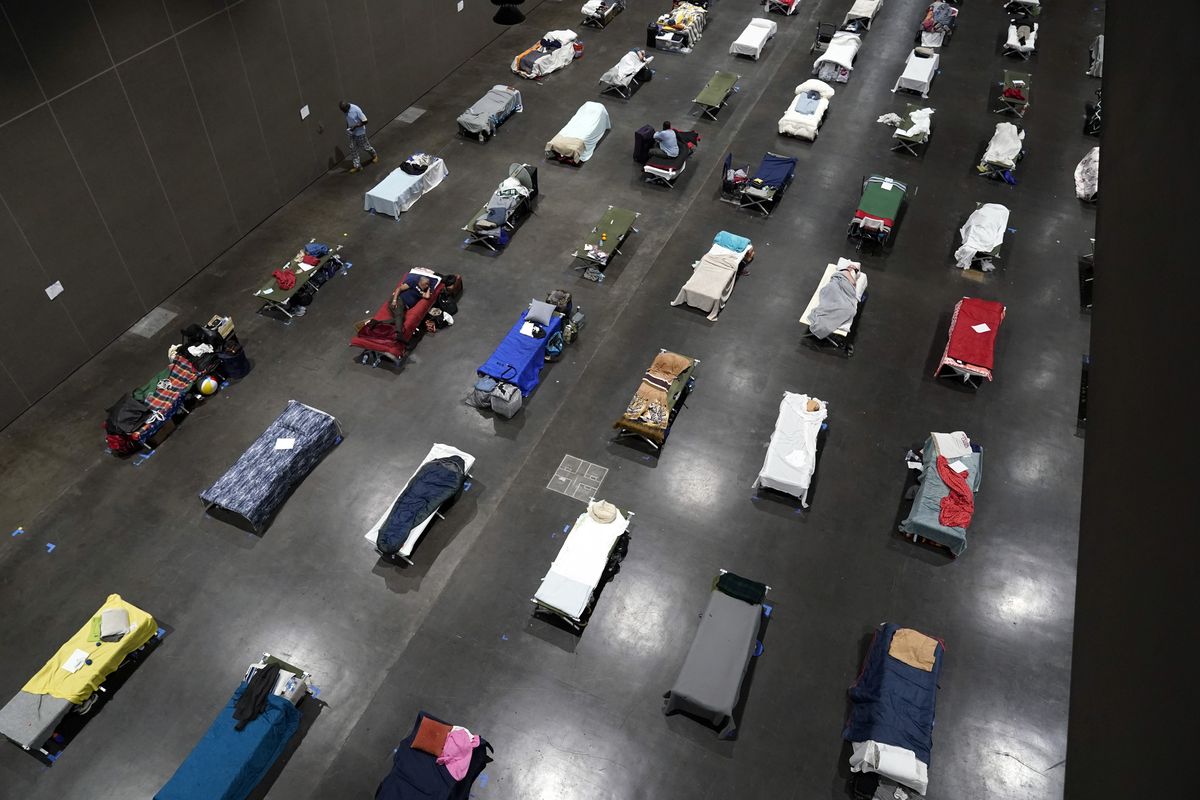 Beds fill a homeless shelter inside the San Diego Convention Center Tuesday, Aug. 11, 2020, in San Diego. When the coronavirus emerged in the United States this year, public health officials and advocates for the homeless feared the virus would rip through shelters and tent encampments, ravaging vulnerable people who often have chronic health issues. Yet, the virus so far does not appear to have brought devastation to the homeless population as many feared.  (Gregory Bull)