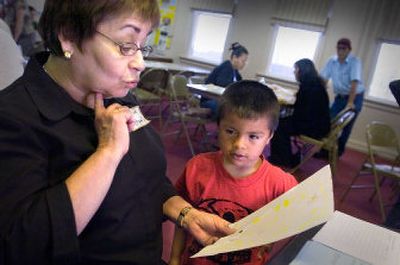 
Madeleine Howeiler comments on the artwork of 4-year-old Danilo Rocha on Saturday. Danilo and his parents, in the background, were getting help at Naturalization Day 2006 at St. Joseph Catholic Church in Spokane. 
 (Christopher Anderson / The Spokesman-Review)