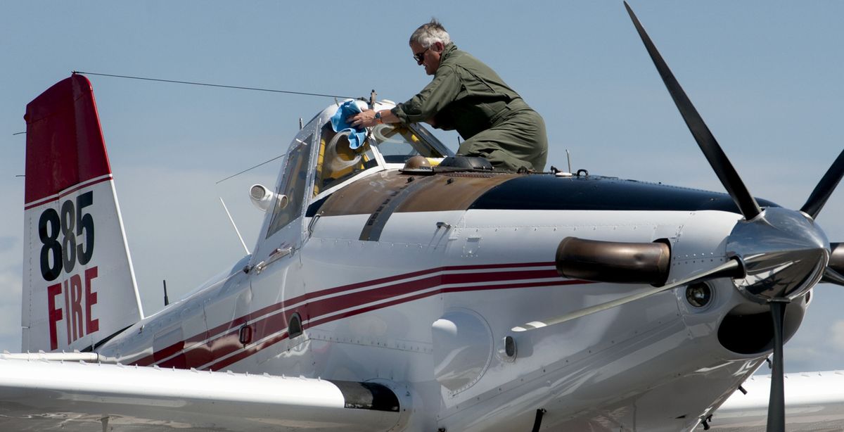Pilot Don MacDonald cleans his windshield after landing for refueling at Coeur d’Alene Interagency Wildland Fire Center on Thursday. He was among pilots helping with efforts to fight the Elevator fire near Idaho’s St. Joe River. (Kathy Plonka)
