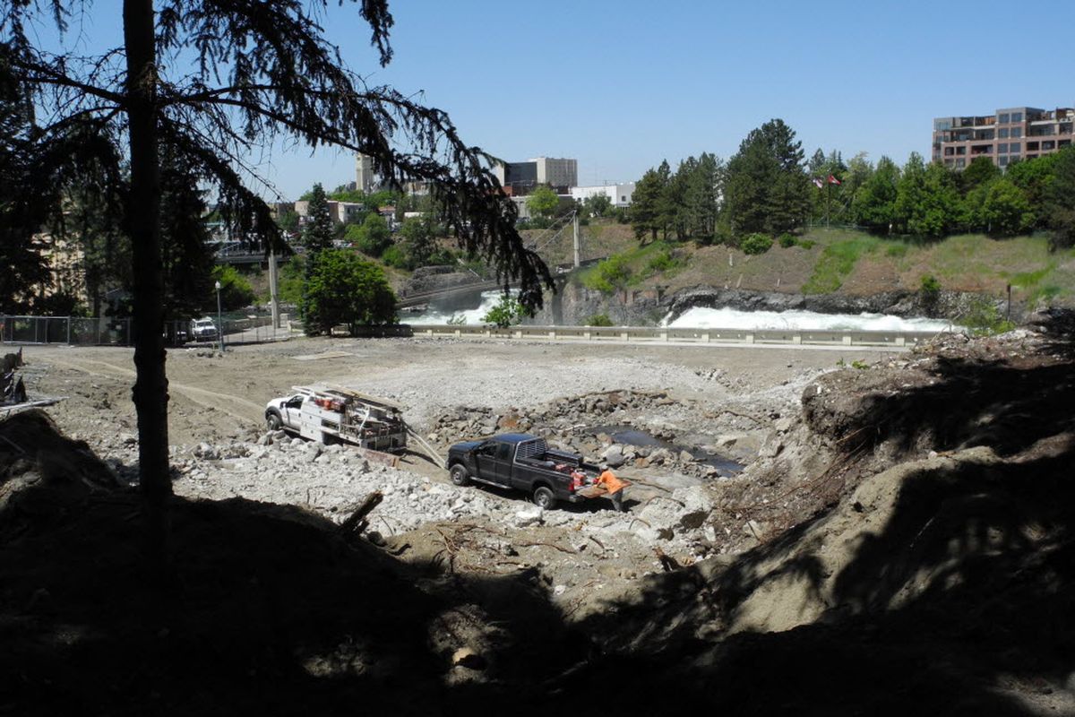 The removal of the old YMCA building in Riverfront Park has opened a new view of the Spokane River and surrounding area. It has also opened a view of the stream - visible just above the work trucks - that ran under the old building.  (Larry Reisnouer / Special to The Spokesman-Review)
