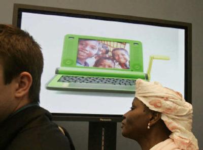 
Summit-goers pass by a picture of the $100 laptop shown on a display at the World Summit on the Information Society at the convention center near Tunis, Tunisia, on Friday. The laptop is designed to make millions of schoolchildren in developing countries computer literate. 
 (Associated Press / The Spokesman-Review)