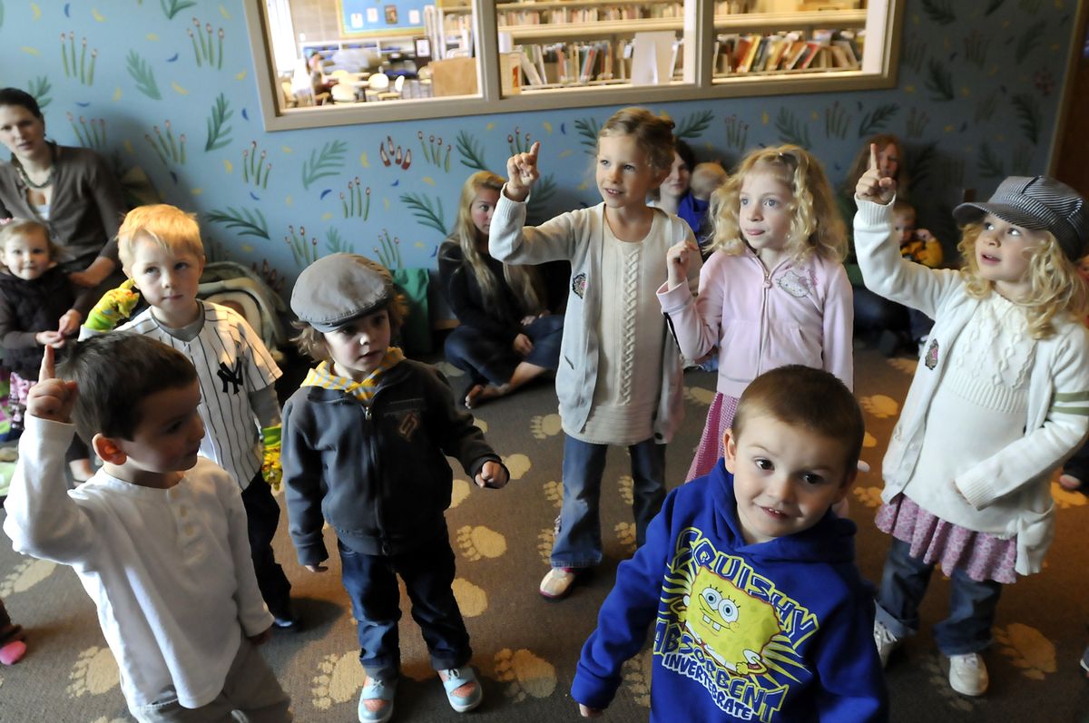 Children join in a counting song at story time Tuesday at the Coeur d’Alene Library. At libraries,  children learn to love reading and have positive adult interactions.  (Jesse Tinsley / The Spokesman-Review)
