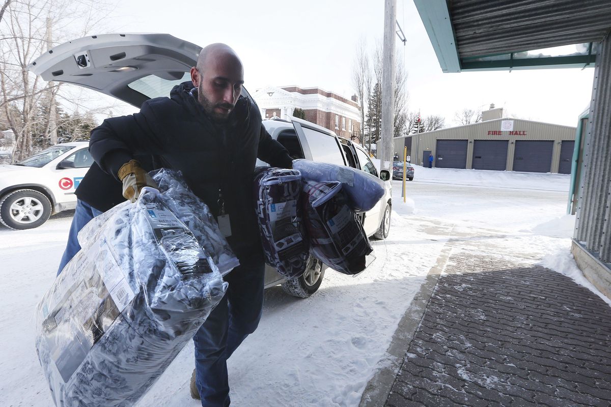 Fadel Alshawwa, Manitoba Interfaith Immigration Council, brings blankets into a community hall for refugees that may walk across the border in Emerson, Manitoba, Thursday, Feb. 9, 2016. (John Woods / Associated Press)