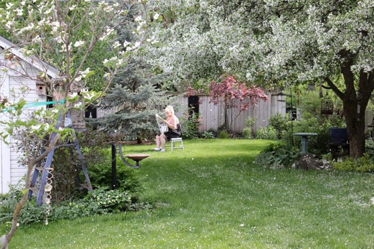Kimberly Dunham reads in the backyard of her Spokane home. Her backyard is certified as Washington wildlife sanctuary, which means she has created areas for animals to get food, water and shelter.  (Courtney Dunham / Down to EarthNW Correspondent)