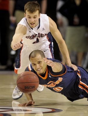 Gonzaga's Kevin Pangos, in back, and Pepperdine's Lorne Jackson (0) chase a loose ball in the first half of their men's college basketball game, Thursday, Feb. 7, 2013, in the McCarthey Athletic Center. (Colin Mulvany / The Spokesman-Review)