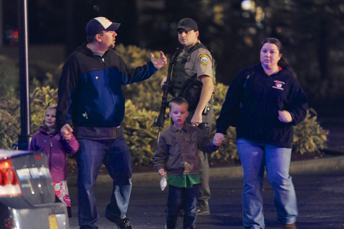 A family leaves the scene of a multiple shooting at Clackamas Town Center Mall in Clackamas, Ore., Tuesday Dec. 11, 2012. A gunman is dead after opening fire in the Portland, Ore., area shopping mall Tuesday, killing two people and wounding another, sheriff