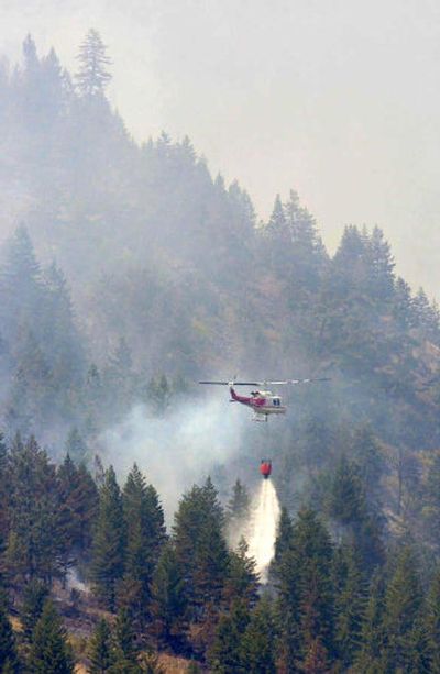 
A helicopter drops water Friday on the West Mountain fire near Alberton, Mont. 
 (Associated Press / The Spokesman-Review)