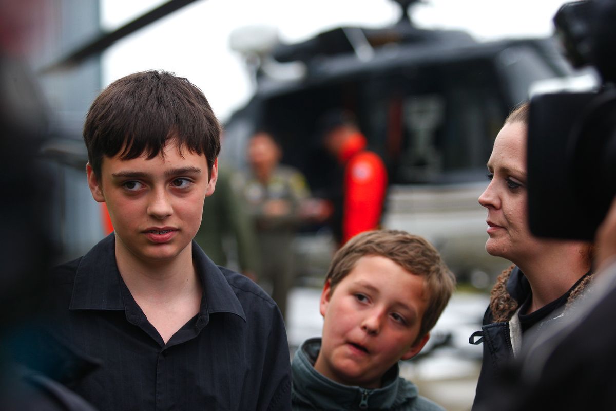 William Hickman, 13, left, his brother Patrick, 9, and his mother, Heather Hickman, field questions from reporters at Snohomish County Volunteer Search & Rescue in Snohomish, Wash., Monday following a harrowing rescue of William from a ledge near the top of 270-foot Wallace Falls on Sunday. (AP/The Herald, Dan Bates)