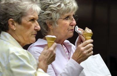 
Sisters Dory Dunn, right, and Joan O'Brien, of Spokane, top off their Pig Out in the Park meal with ice cream Wednesday afternoon in Riverfront Park. 
 (Holly Pickett / The Spokesman-Review)