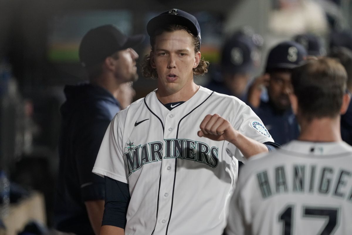 Seattle Mariners starting pitcher Logan Gilbert is greeted in the dugout by Mitch Haniger, right, after the top of the third inning of a baseball game against the Oakland Athletics, Wednesday, Sept. 29, 2021, in Seattle.  (Associated Press)