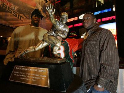 
Heisman Trophy award finalists  Vince Young, left, of Texas, and running back Reggie Bush of USC, get an up-close look at the trophy Friday. 
 (Associated Press / The Spokesman-Review)