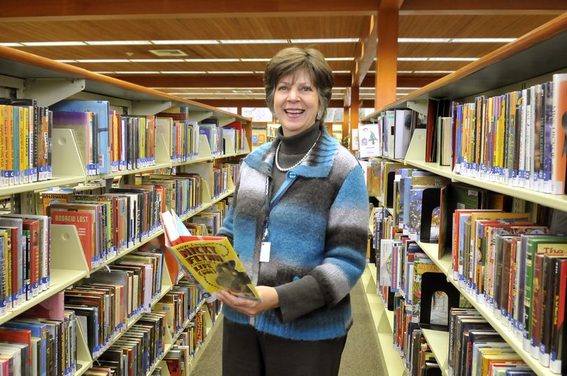 Nancy Ledeboer holds a book in the Argonne Library branch Wednesday. Ledeboer is the new administrator of the Spokane County Library District. (Jesse Tinsley)