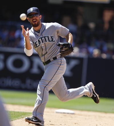 Seattle 2B Dustin Ackley flips a quick throw to first to nail a runner Sunday. (Associated Press)