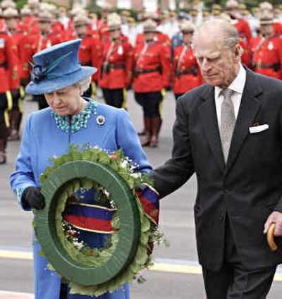 
Queen Elizabeth II and Prince Philip place a wreath during a memorial for four Mounties. 
 (Associated Press / The Spokesman-Review)