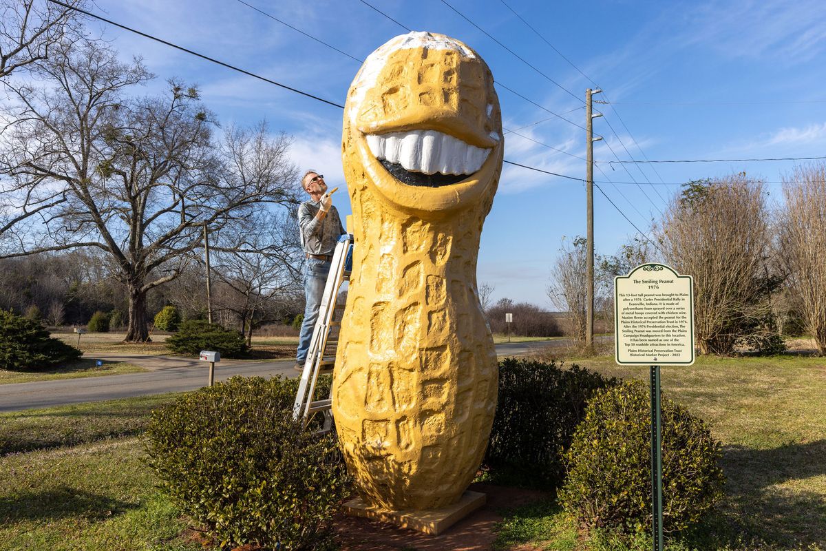 Plains resident Michael Dominick paints the Smiling Peanut in Plains on Sunday, Feb. 19, 2023.    (Arvin Temkar/The Atlanta Journal-Constitution/TNS)