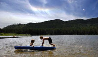 
Brothers Phyl, left, and Ed Frets of Clagstone, Idaho, play on a kayak in shallow water at Round Lake on Wednesday.  A governor-appointed task force is studying whether to recommend that Idaho register nonmotorized boats such as canoes and kayaks. 
 (Kathy Plonka / The Spokesman-Review)