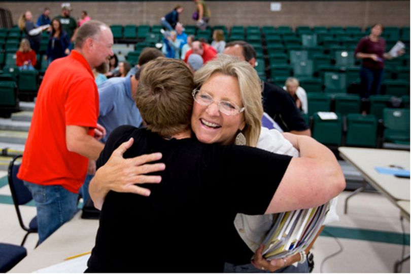 Kelly Ostrom, director of human resources for the Coeur d'Alene School District, receives a hug from Borah Elementary School teacher Kerry Erwin after the district and teachers union came to a tentative agreement over teacher contracts on Wednesday at Woodland Middle School. (JAKE PARRISH/CDA PRESS)