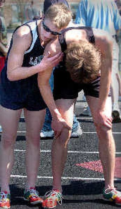 
Lake City's John Coyle, left, leans on Steven Farr of Post Falls after winning 3,200 and setting a meet record. 
 (Jesse Tinsley / The Spokesman-Review)