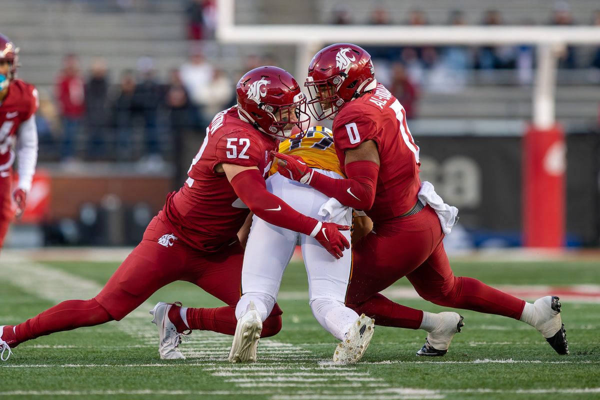 Washington State Cougars linebacker Kyle Thornton (52) and linebacker Taariq Al-Uqdah (0) bring down Wyoming Cowboys quarterback Evan Svoboda (17) in the first half on Saturday, Nov. 30, 2024, at Gesa Field in Pullman, Wash.  (Geoff Crimmins/For The Spokesman-Review)