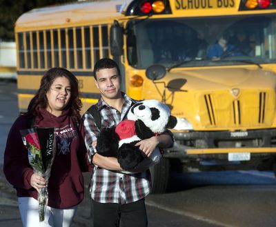 Bearing gifts: Brooke Escalera, 16, carries roses while Tristan Clark, 16, snuggles a stuffed panda bear as they walk to morning classes at Ferris High School in Spokane on Thursday. Clark was planning to surprise his girlfriend, Megan Wallace, with the gifts for Valentine’s Day. Wallace is also a Ferris student. Clark purchased the panda from Kmart, and the roses came from Safeway. (Dan Pelle)