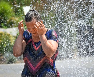 Caralynne Farnsworth, of Spokane, takes her second trip through Riverfront Park’s Rotary Fountain to cool off as temperatures soared into the 90s Monday. “The water sets me free,” she said.  (DAN PELLE/THE SPOKESMAN-REVIEW)