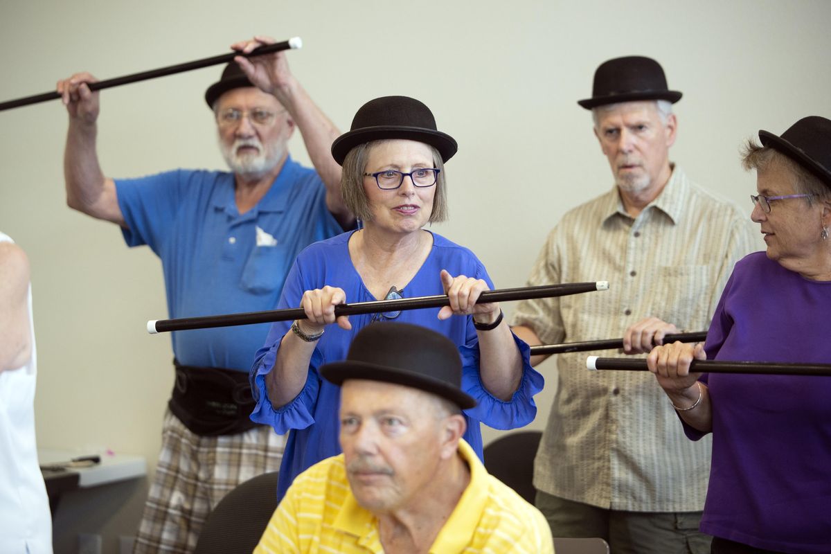 Sue Swanson, center, rehearses a number for a musical that her group, Happy Dance, is rehearsing for family and friends Tuesday, July 31, 2018 at the Northwest Parkinsons Foundation office. The music, dance and dialogue challenge the group of Parkinsons patients and their spouses to push themselves. (Jesse Tinsley / The Spokesman-Review)
