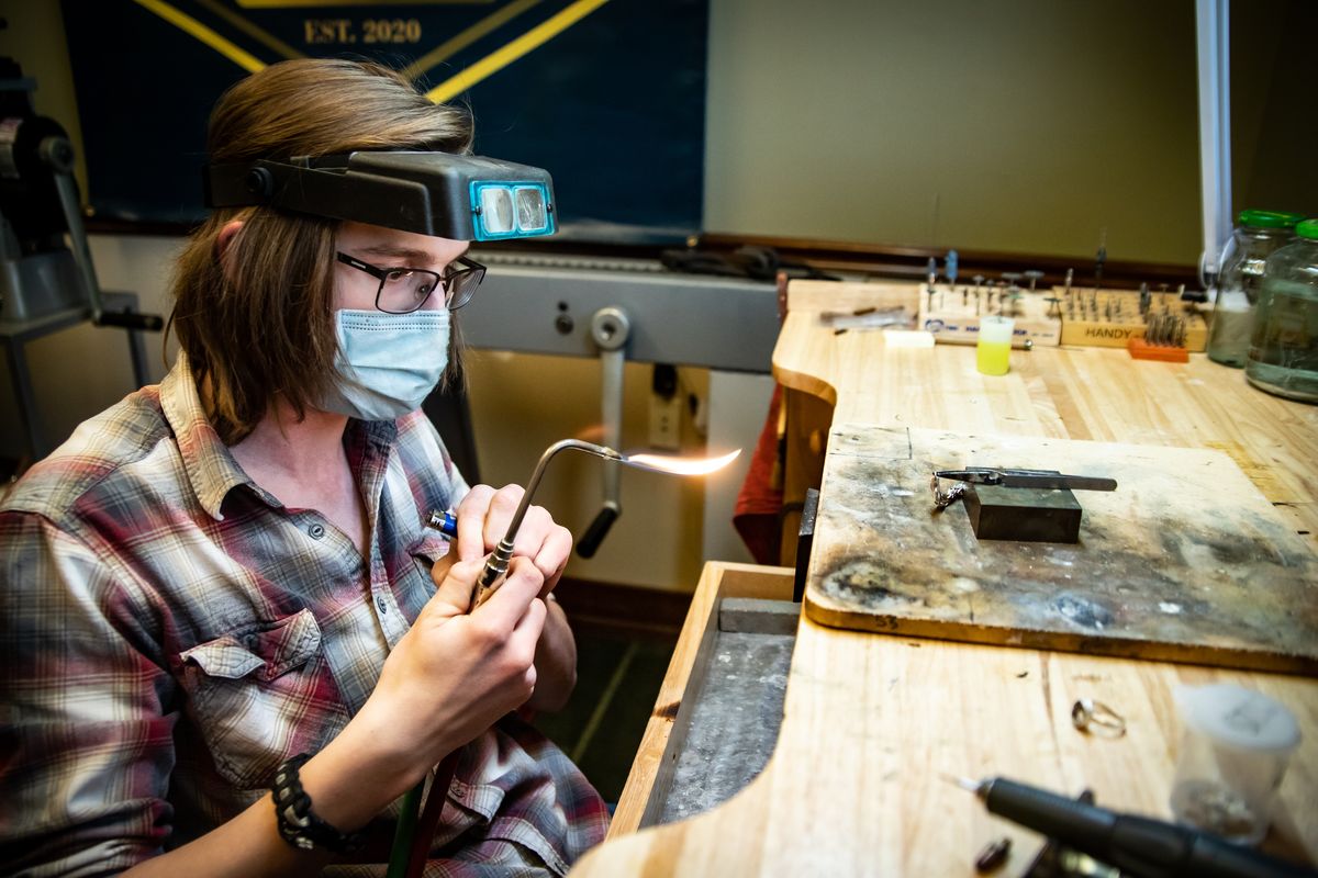 Senior Nathan Flinn of On Track Academy works on a silver chain on May 13, 2021 in his role as an apprentice at Honeybee Goldsmiths in Spokane, Wash. Flinn works as an apprentice for Nathan Fromviller, third-generation goldsmither and owner of Honeybee Goldsmiths. Flinn is passionate about the profession and plans to make a career out of goldsmithing.  (Libby Kamrowski/ THE SPOKESMAN-REVIEW)