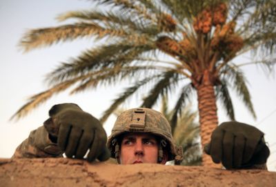 A U.S. Army soldier from Hammer Company, 3rd Squadron, 2nd Stryker Cavalry Regiment, peers over a wall at detainees in Nahr al-Imam, Diyala province, on Wednesday.  (Associated Press / The Spokesman-Review)