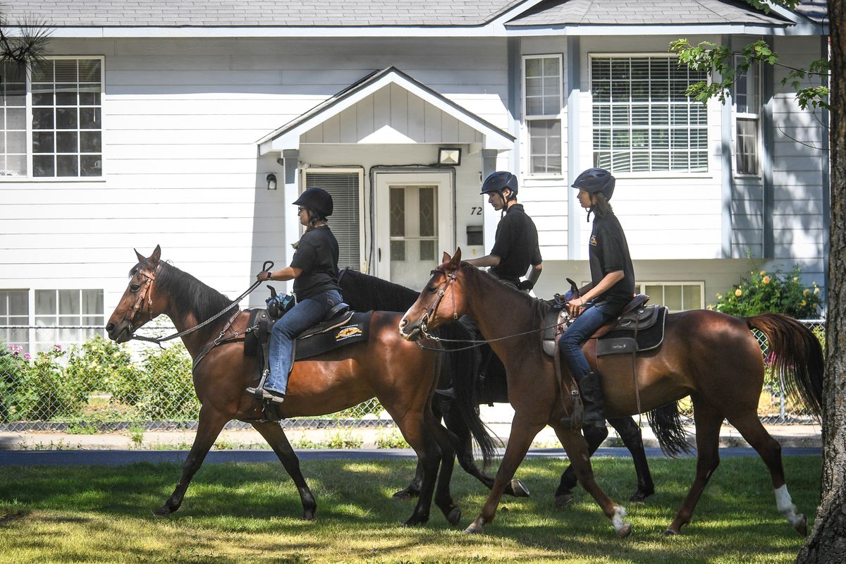 C.O.P.S. Mounted Patrol members, from left, Brandy Cusick, riding Josie, Carson Anselmo Marnach, riding Archie, and Devon Anselmo Marnach, atop Bella, take a spin around Glass Park, Tuesday, Aug. 4, 2020, in Spokane.  (DAN PELLE/THE SPOKESMAN-REVIEW)